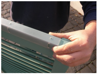 close up of hand holding hidden bracket on top of shutter