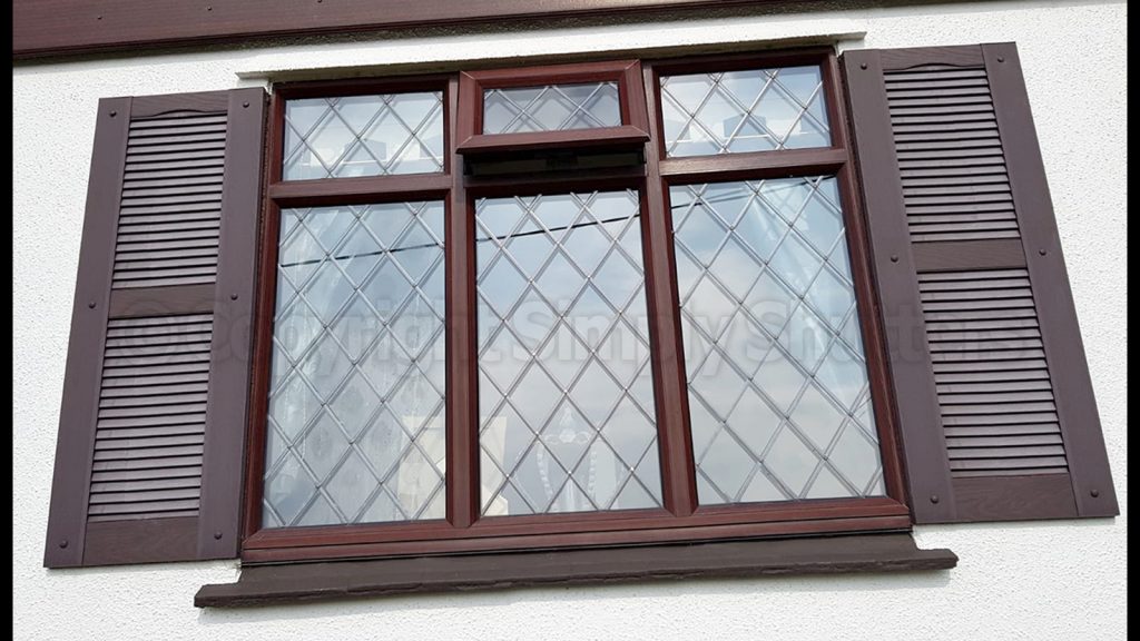window with brown decorative shutters