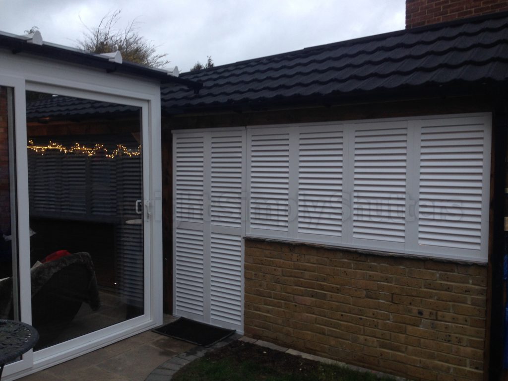 white louvre shutters fitted over a window 