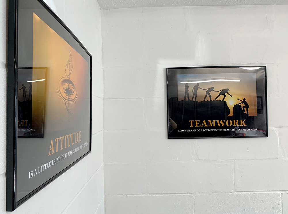 two framed motivational posters on white wall 