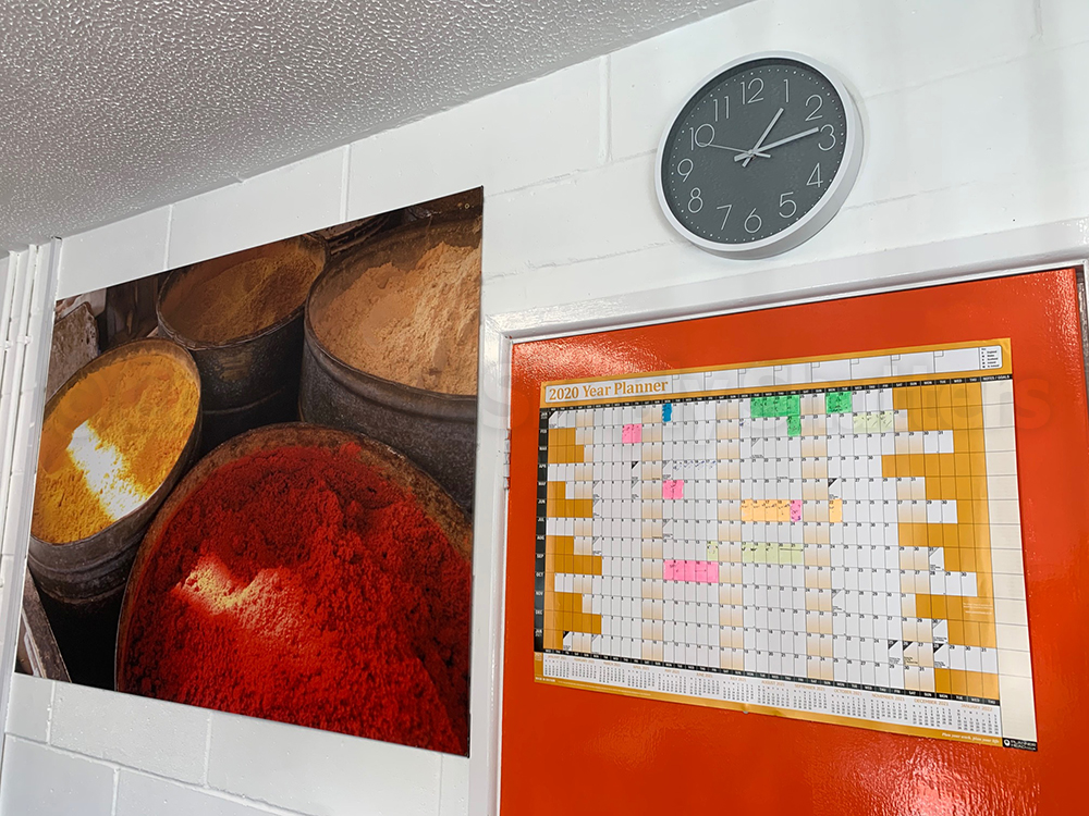 large picture and clock on wall and orange door