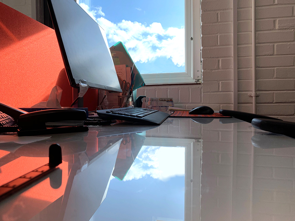 close up of office desk with window in background