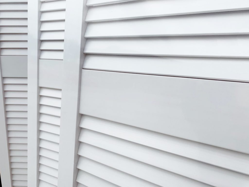 close up offset horizontal bar on white louvre door 