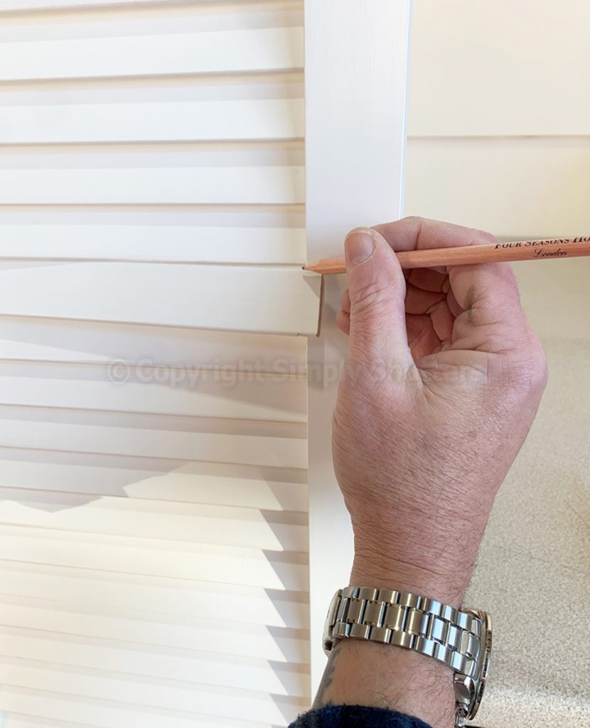 Hand marking louvre blade with pencil. 