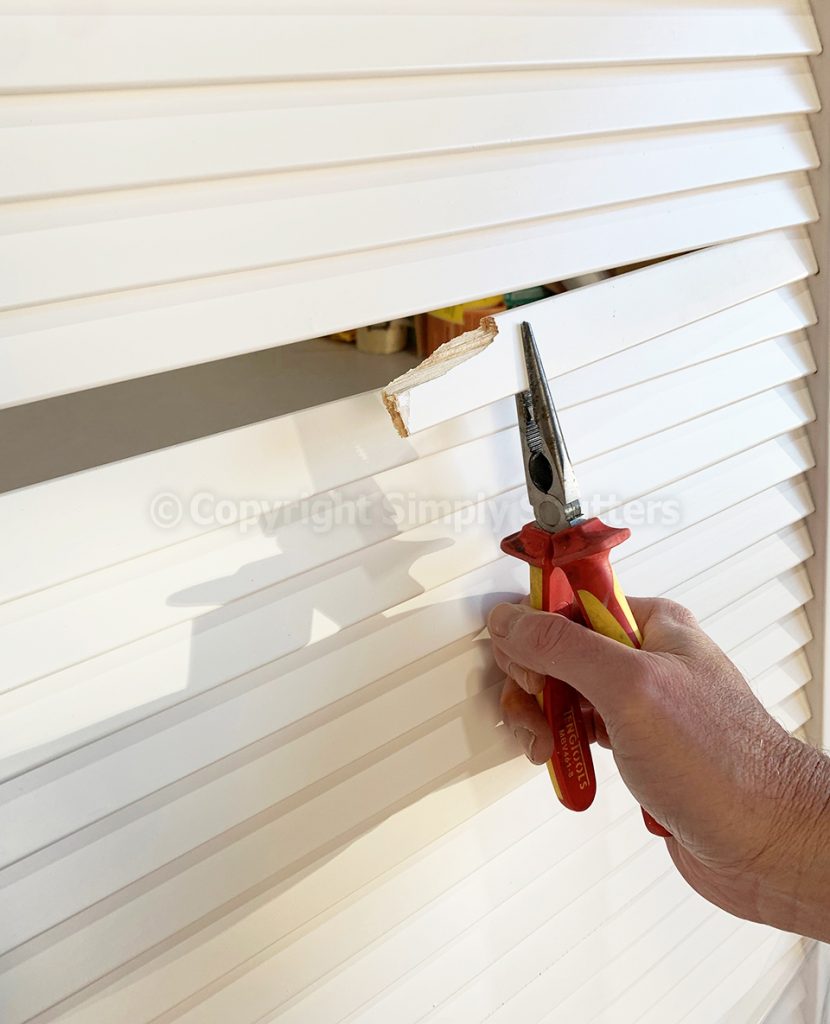 Hand on pliers removing broken blade for louvre door 