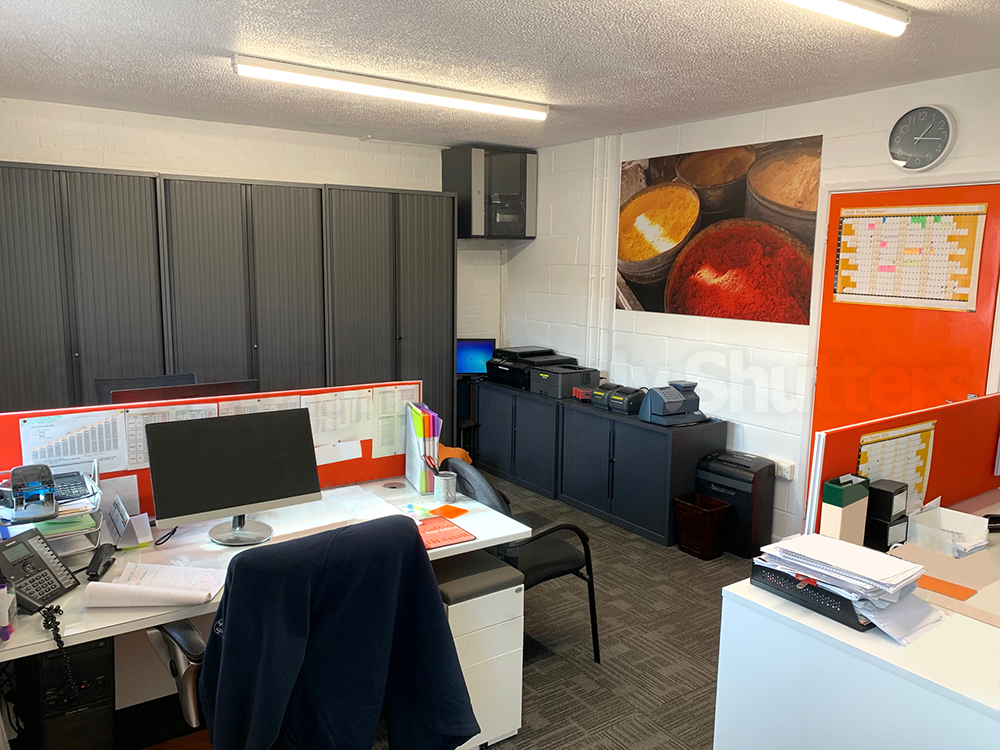 Office with table chairs and tambours and orange and grey decor 
